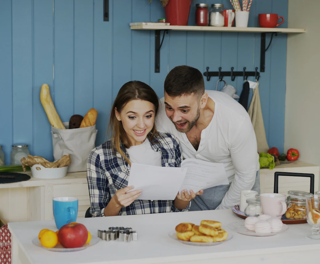 Smiling couple at home reading a letter together
