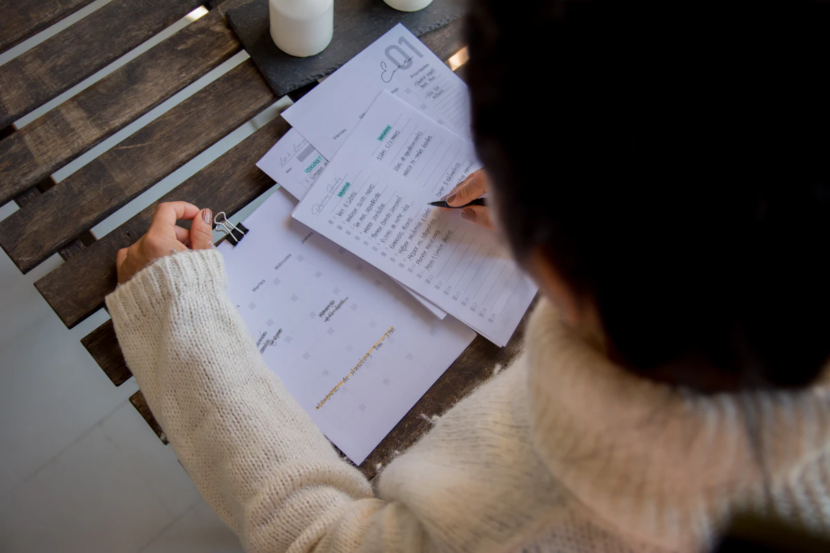 A person filling in a paper form at a desk.